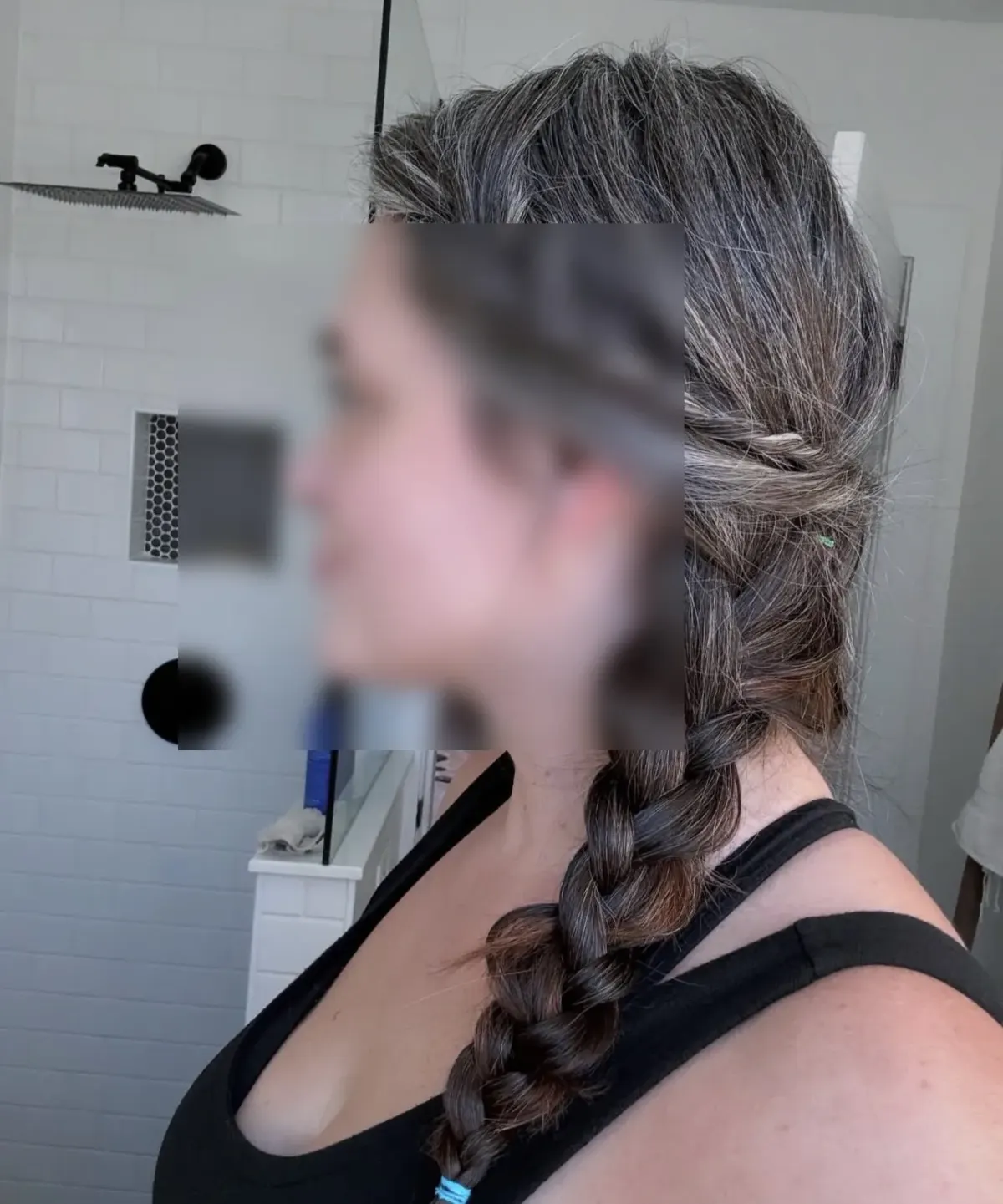 Side portrait of a person with braided hair and blurred face in a bathroom, suggesting discretion for kink dating profiles Side portrait of a person with braided hair and blurred face in a bathroom, suggesting discretion for kink dating profiles